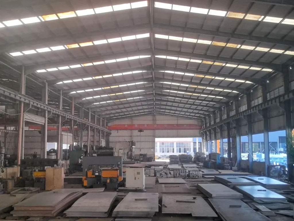 Steel structure factory interior with machinery and raw materials​