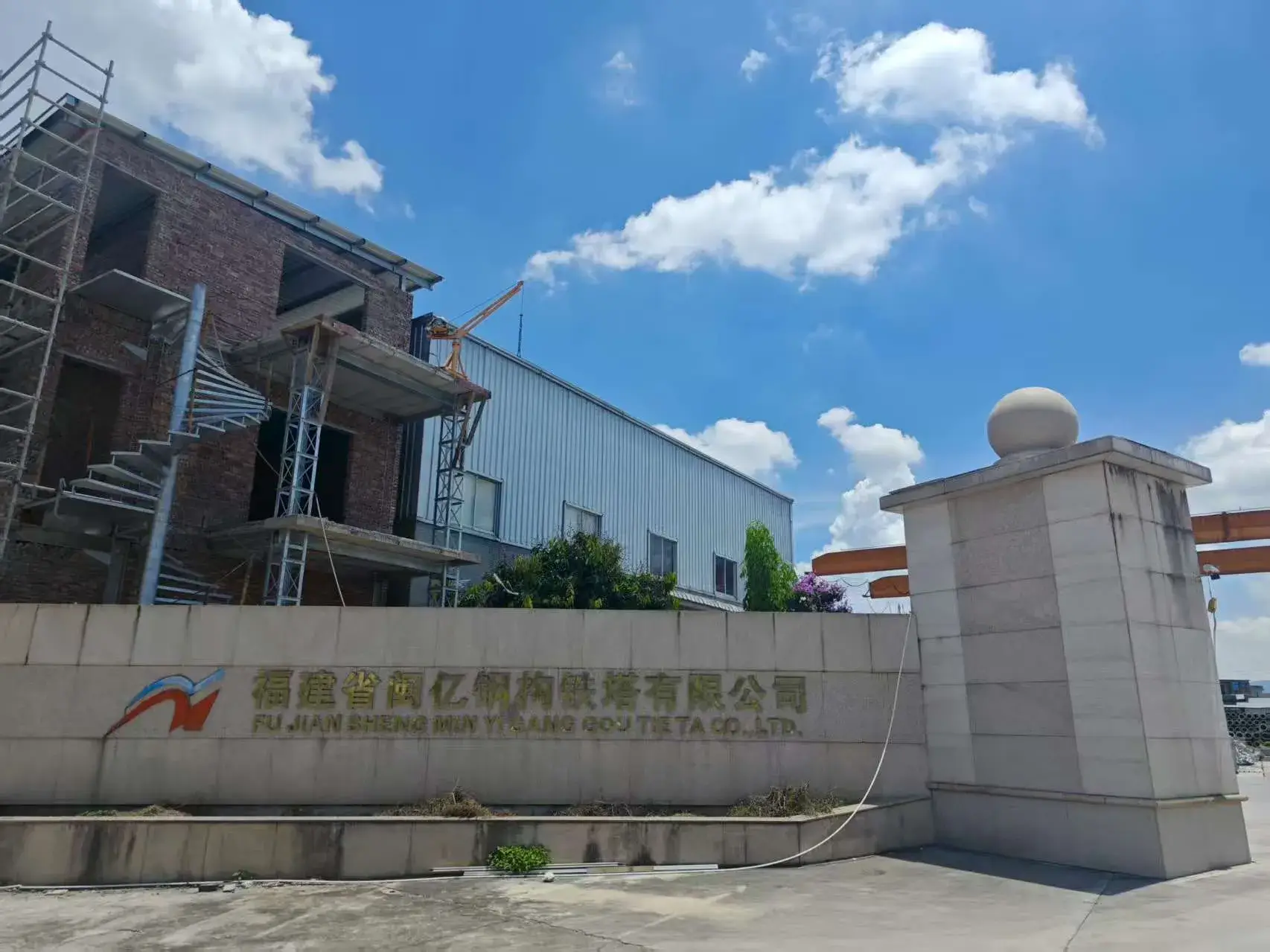 ​​Fujian Minyi Steel Tower factory with crane under blue sky​
