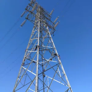 Workers maintaining tall transmission tower against