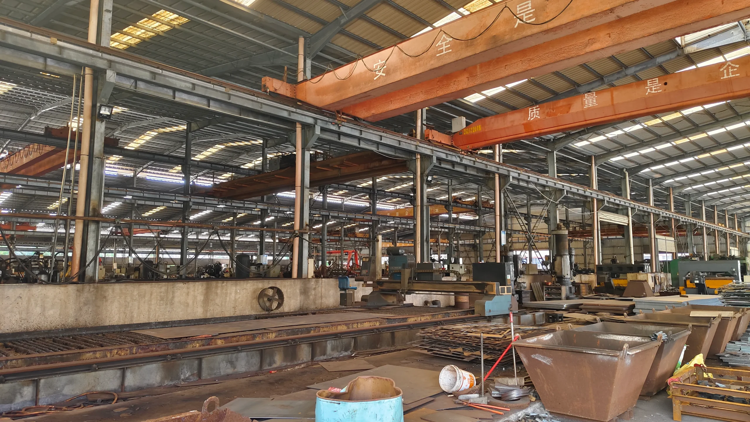 ​​Factory interior with safety slogans and structural steel framework​